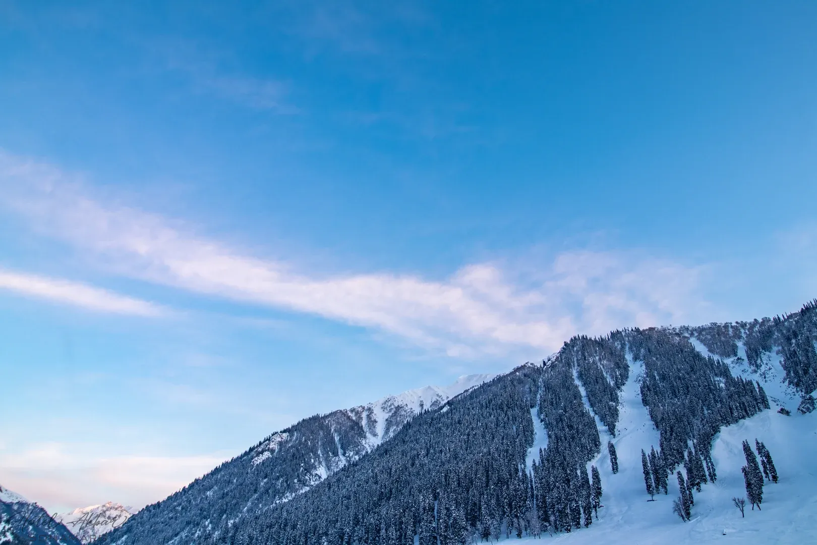 Majestic snowy peaks under blue sky.