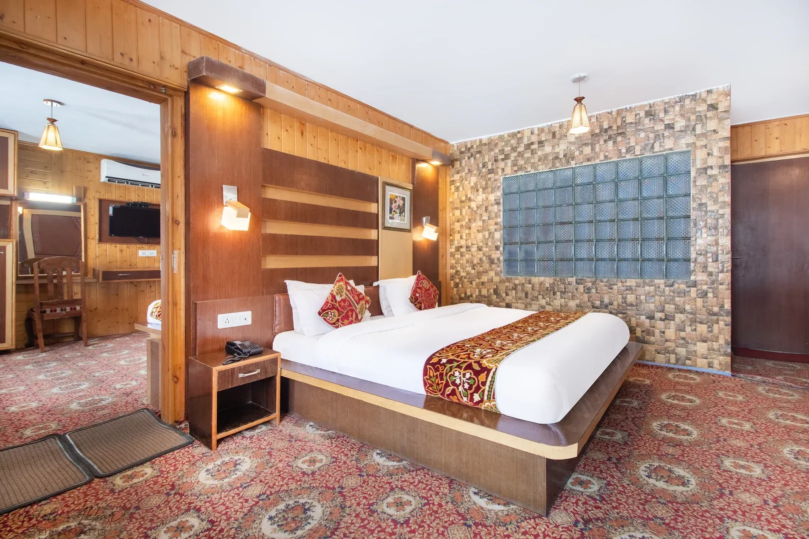 Spacious luxury bedroom featuring stone headboard accents.